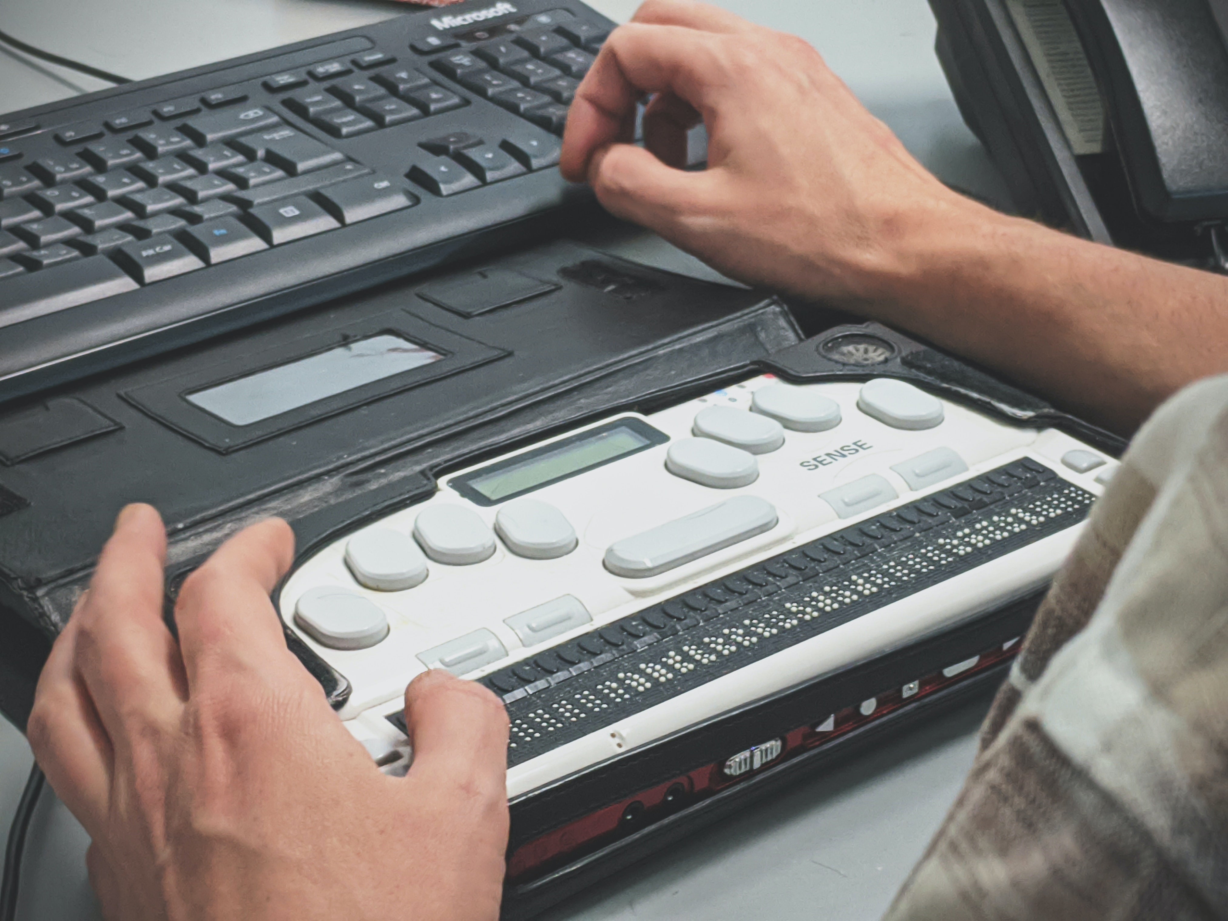 person interacting with braille keyboard