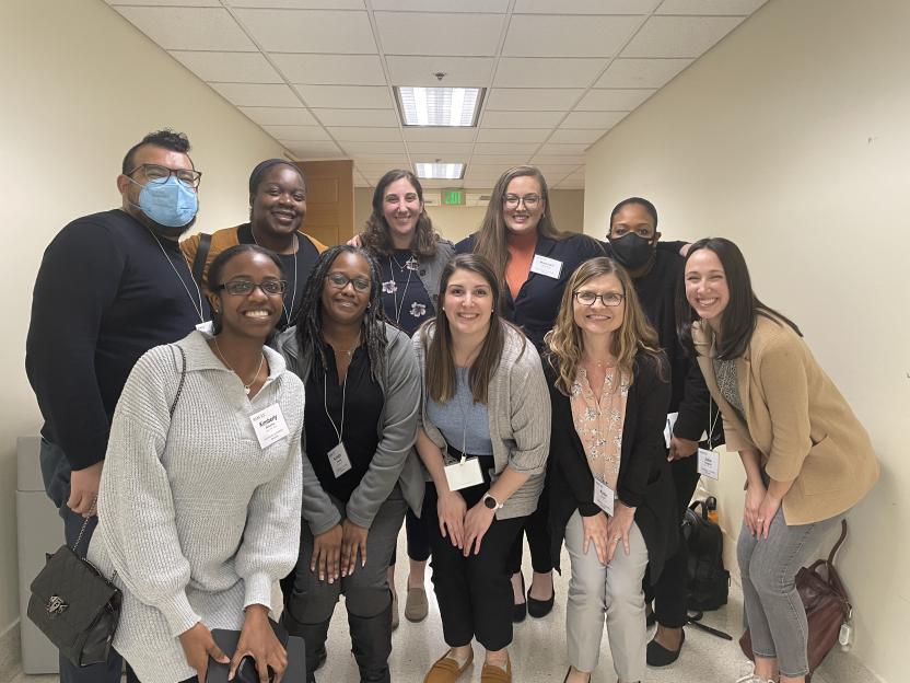 10 ADS staff members posing in a hallway