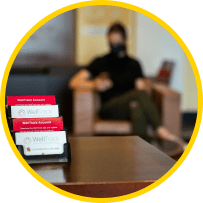 business cards on table in the foreground and student sitting in waiting area in the background