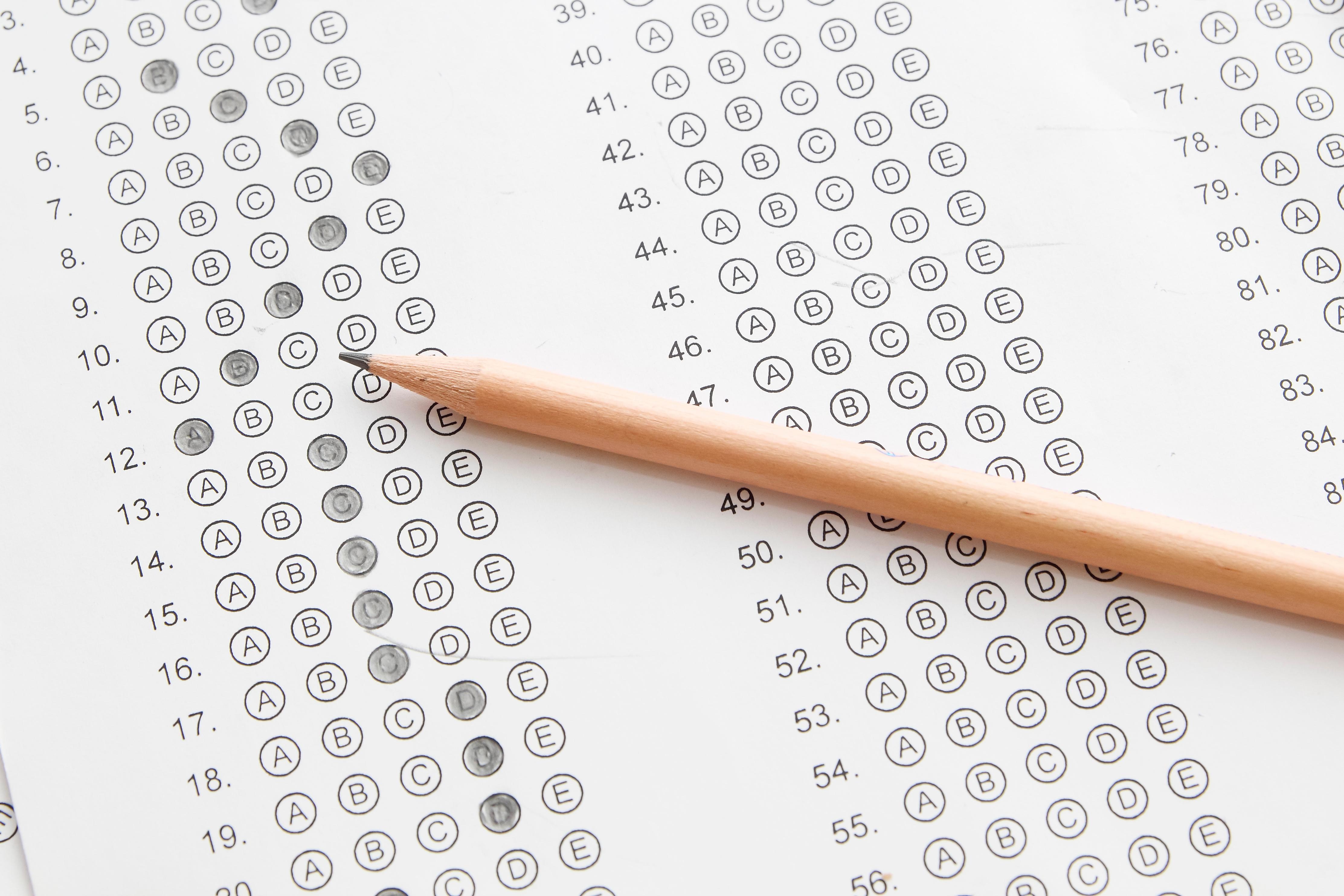 yellow number 2 pencil laying on top of a completed test scantron