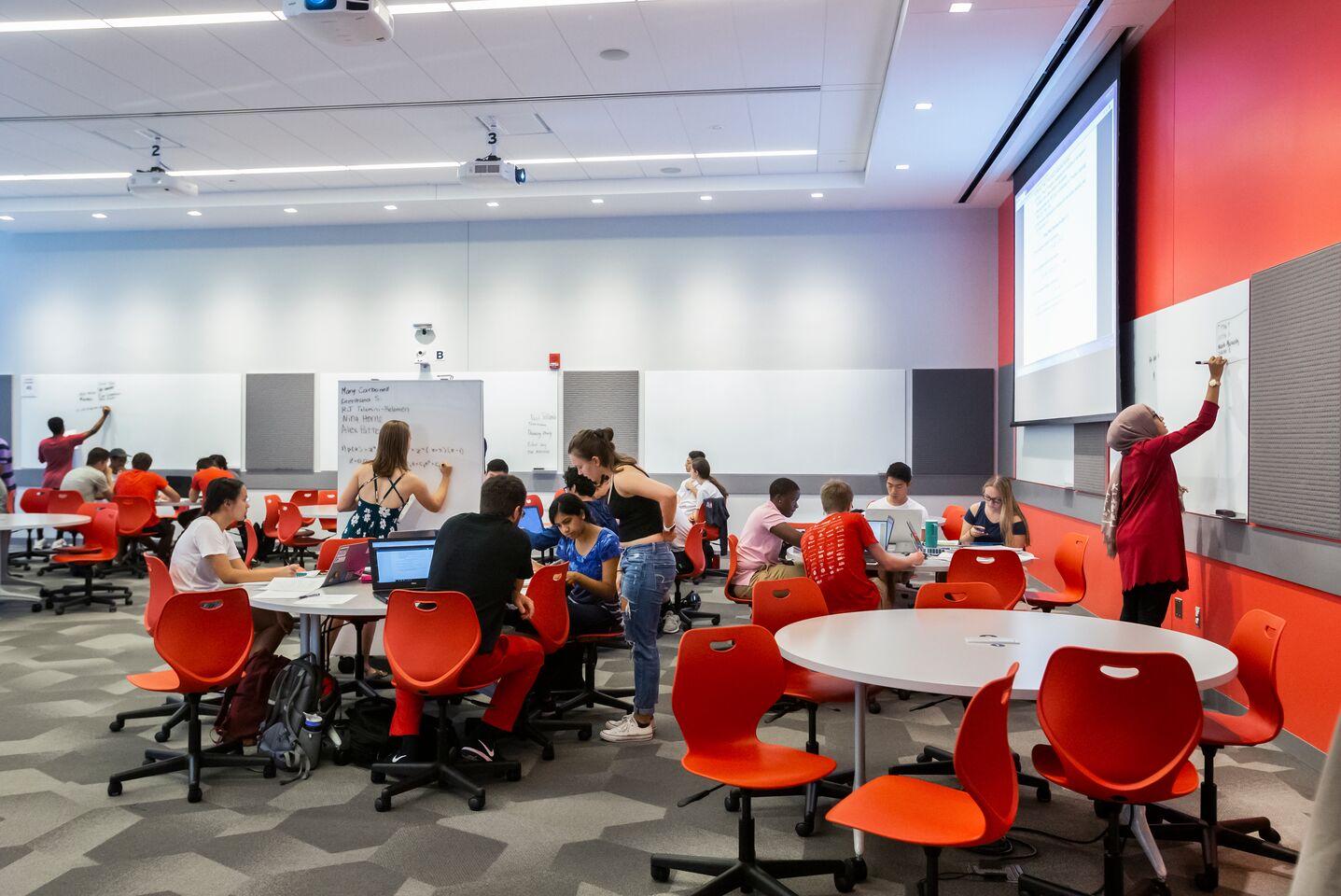 Students working a modern classroom in the Edward St. John Learning and Teaching Center.