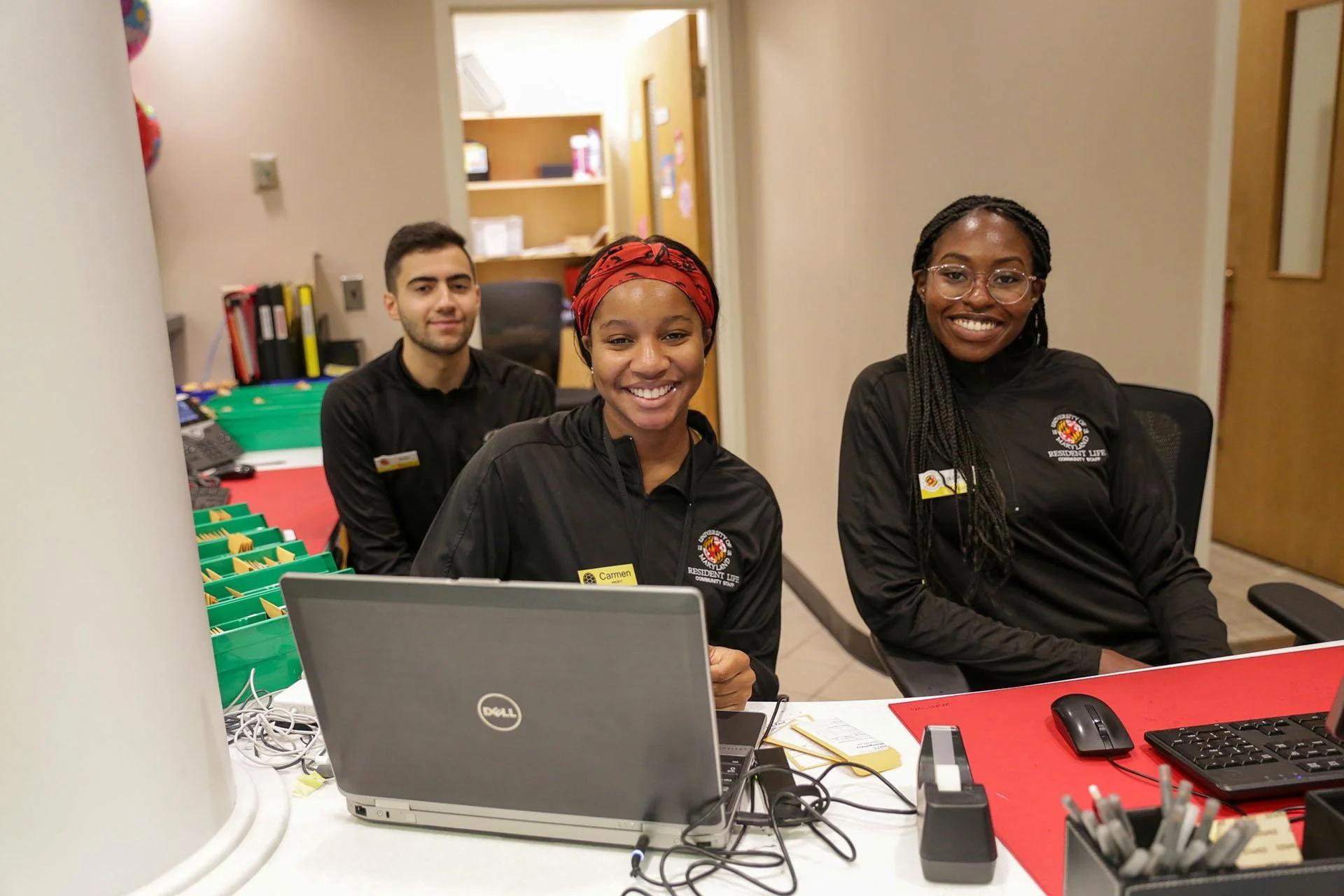 three community assistants behind a service desk